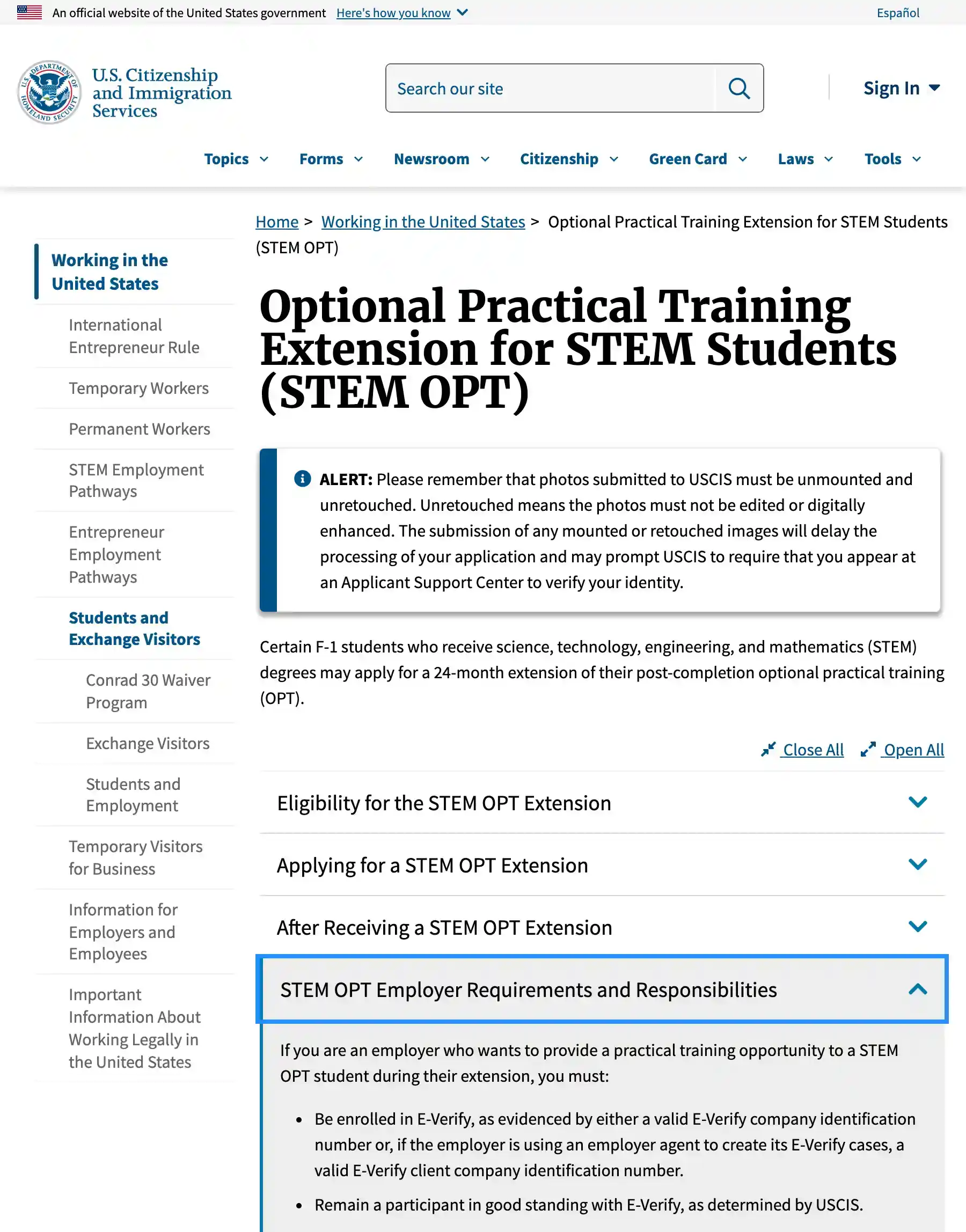 The USCIS page on the STEM OPT extension under the official U.S. government banner, with the employer requirements section open: be enrolled in E-Verify and remain a participant in good standing.